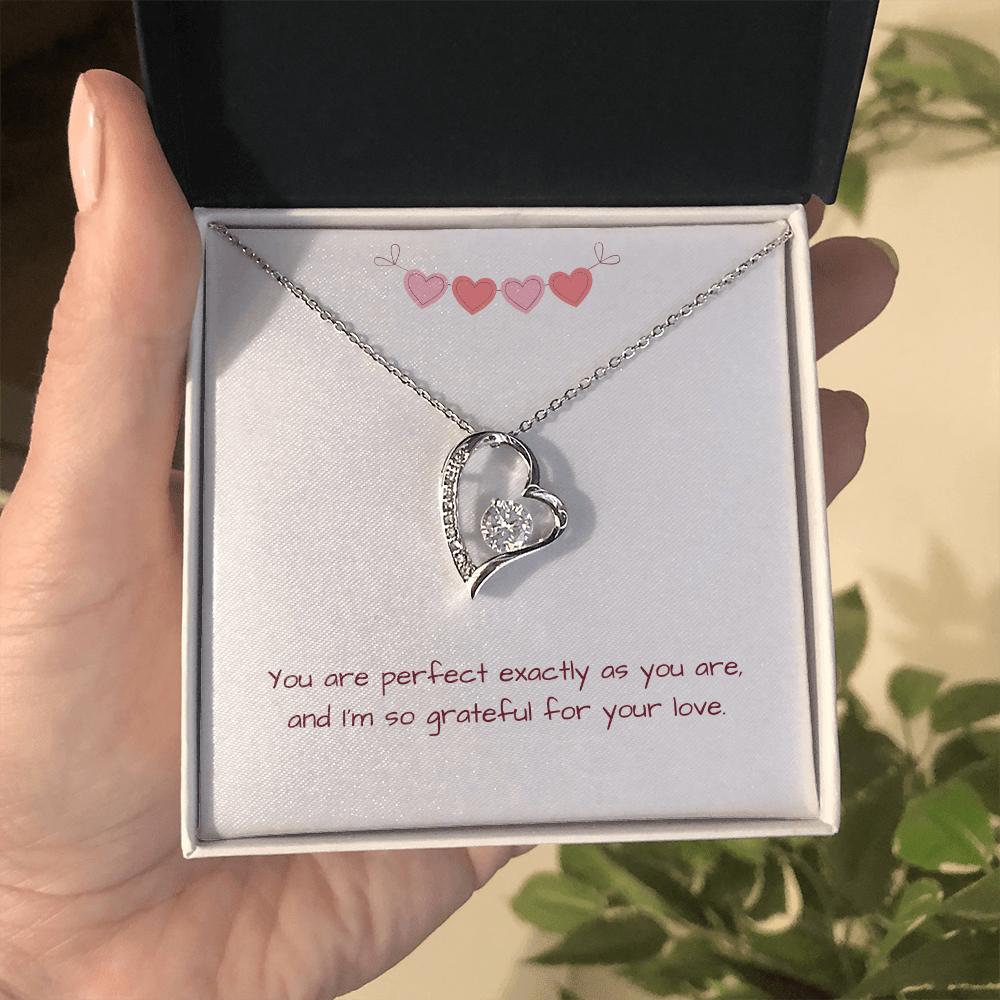 Hand holding silver Perfectly You Heart Necklace with gift box and message card